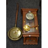 A mid-20th century oak wall-hanging pendulum clock, twin winding holes,