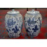 A pair of oriental style ovoid blue and white jars and covers. 48c high x 30cm diameter.