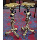 A modern pair of giltwood Blackamoor tripod torcheres.