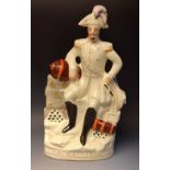 A Staffordshire flatback, Napoleon III, seated, leaning on a cannon, lightly coloured,