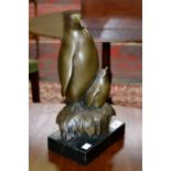 A contemporary bronzed figure group of a penguin and chick.