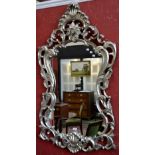 A contemporary cartouche silver gilt framed mirror, foliated decoration throughout.