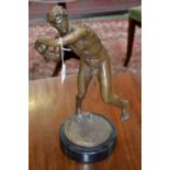 A contemporary bronzed figure of a male shot putter.