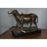 A contemporary bronzed model of a water buffalo on a marble base