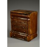 A 19th century treacle glazed novelty money box, as a chest of drawers, coin aperture to verso,