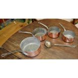 A set of four graduated copper pans;