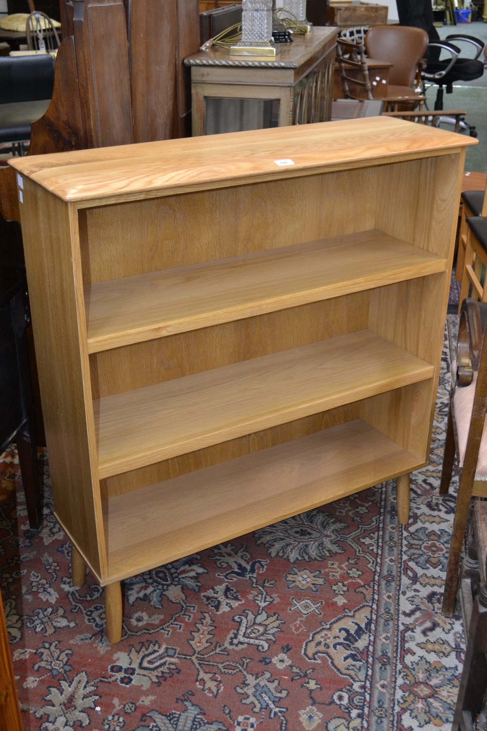 An Ercol style light oak three tier bookcase.
