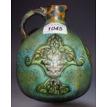 A Chameleon ware Persian Art pattern ewer, glazed in mottled shades of green and brown,