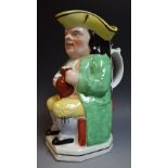 A 19th century Toby jug, yellow hat, green long tail coat, yellow breeches, ale jug, 23.