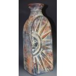 An Art pottery red clay vase, in relief with sun, mottled in orange, blue and red, 28.