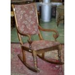 A Regency mahogany rocking chair, padded back, scrolling open arms, padded seat, turned forelegs.