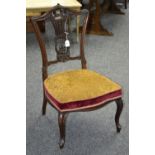 A late Victorian mahogany nursing chair, ornate carved back,