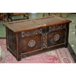 An 18th century small oak coffer, two panelled hinged cover, two carved panels to front, stile feet,