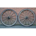 A pair of vintage cart wheels with vulcanized rubber applied to the rim.