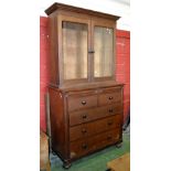 An oak bookcase chest, stepped cornice, two glazed doors enclosing adjustable shelving,