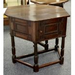 An oak credence cupboard, hinged top opening to unequal octagon, panel door cupboard, turned legs.