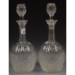 A pair of cut and pressed glass globular decanters and stoppers