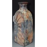 An Art pottery red clay vase, in relief with sun, mottled in orange, blue and red, 28.