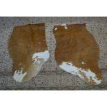 A pair of quarter size brown and white cow hides