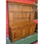 A light oak dresser, ogee cornice, shelves, cupboards and drawers to top,