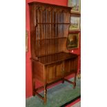 An oak dresser, outswept cornice, shaped and pierced apron over two shelves to top,