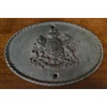 A vintage cast iron oval wall plaque bearing the Royal Coat of Arms.