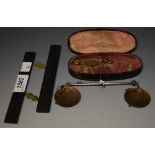 An early 19th century brass and steel sovereign balance, toleware case,