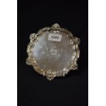 A George V silver waiter, three pad feet, fluted shell and scroll border,