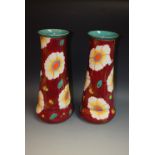 A pair of Losol ware vases, floral decoration on burgundy ground, turquoise interior,