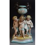 A Continental porcelain group, three cherubs,