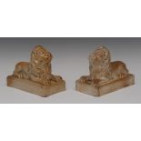 A pair of Brampton brown salt glazed stoneware models of a recumbent lions, rectangular bases,