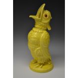 An unusual Grotesque Bird vase, glazed in yellow, with beak open wide, glass eyes,