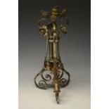 An Arts and Crafts wrought iron tripod table lamp in the style of Benson,