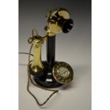 A 1920s brass and cast metal dial-up candlestick telephone, daffodil mouth piece, by UT,