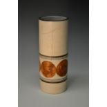 A Troika cylindrical vase, decorated with tan roundels banded in blue and black on a cream ground,