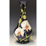 A contemporary Moorcroft Chatsworth Orchid pattern bottle vase, designed by Philip Gibbon,