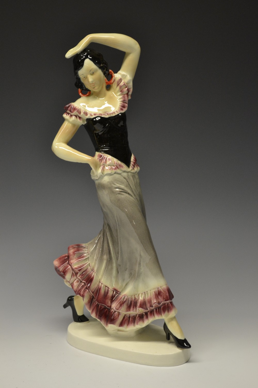 A large continental earthenware model of a Flamenco Dancer, glazed in glossy tones of pink, grey,