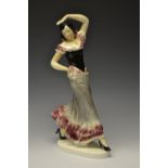 A large continental earthenware model of a Flamenco Dancer, glazed in glossy tones of pink, grey,