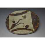 A Studio Pottery oval dish glazed in shades of brown and cream, raised on two small feet, 23.