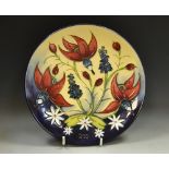 A contemporary Moorcroft circular plate, tube lined with fuchsias and cornflowers, 22.