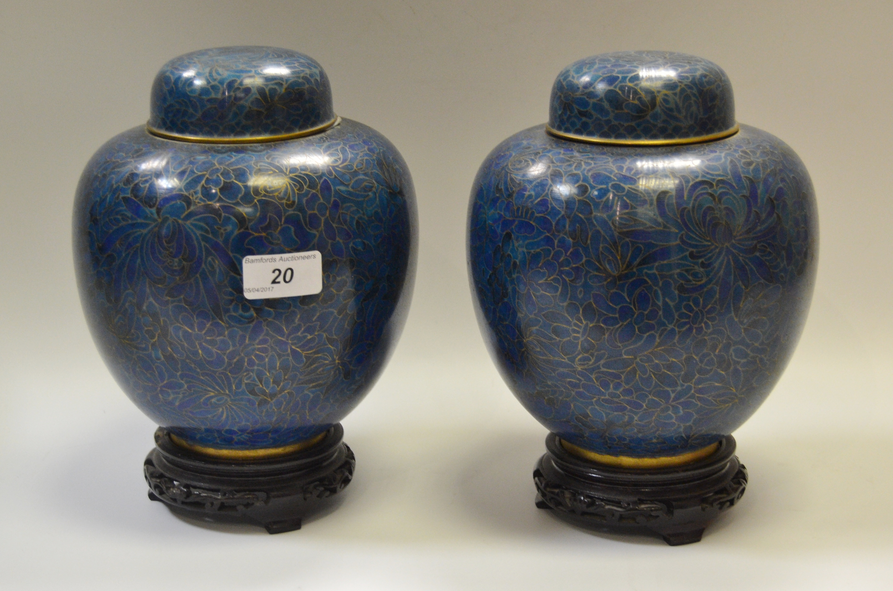 A pair of cloissone ginger jars and covers, decorated with leaves and flowers,