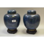 A pair of cloissone ginger jars and covers, decorated with leaves and flowers,