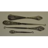 An Edwardian silver hafted shoe hook, the haft embossed with leafy scrolls, Chester 1898; another,