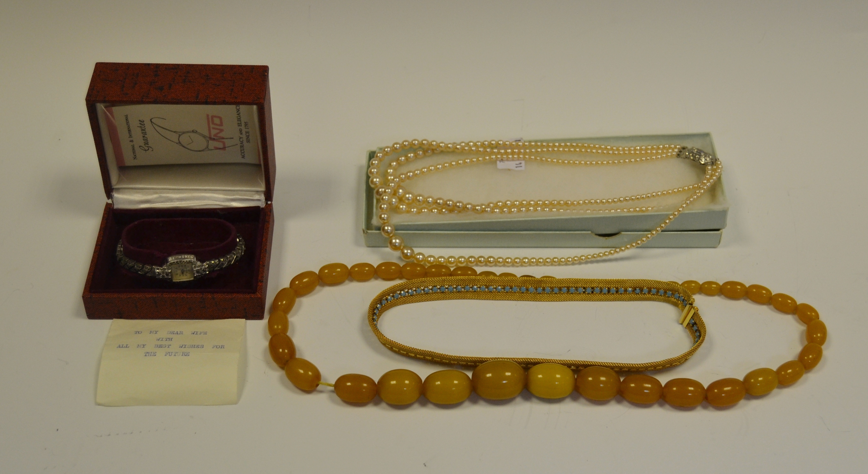 A set of faux Amber beads; a necklace of faux pearls;