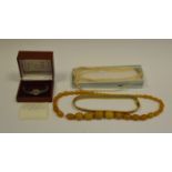 A set of faux Amber beads; a necklace of faux pearls;