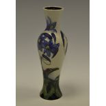 A contemporary Moorcroft slender ovoid vase, tube lined with blue flowerheads and ladybird,