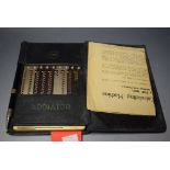 An Addiator (Gesellschaft, Berlin), pre-decimal calculating machine, folding leather wallet,