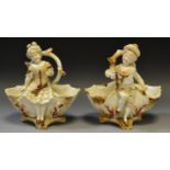 A pair of Continental porcelain figural table salts as a Dandy and his Beau beneath branches,