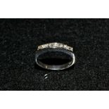 A diamond seven stone ring, channel set with seven round cut diamonds,