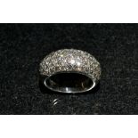 A diamond dress ring, pave encrusted with sixty round cut diamonds,